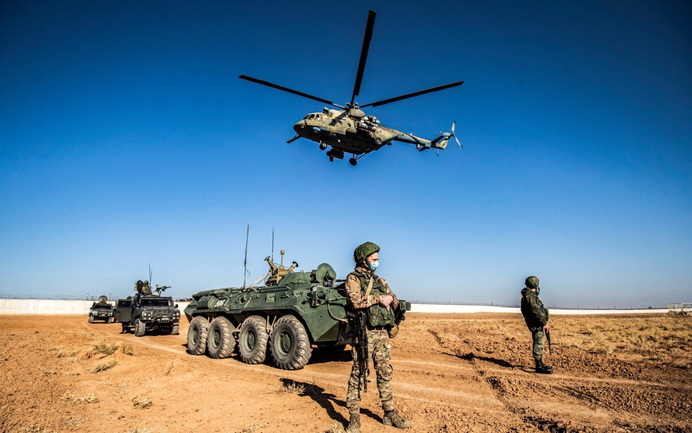 Un hélicoptère militaire russe Mil Mi-17 survole des soldats et des véhicules militaires lors d’une patrouille conjointe russo-turque en Syrie (AFP)