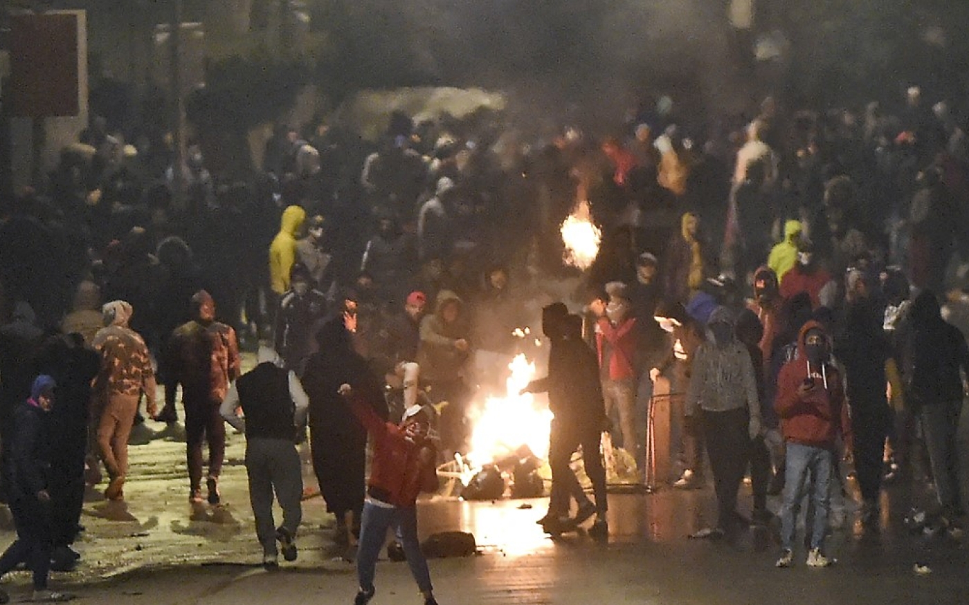 Des manifestants bloquent une rue lors d’affrontements avec les forces de l’ordre, à Ettadhamen, le 18 janvier 2021 (AFP)