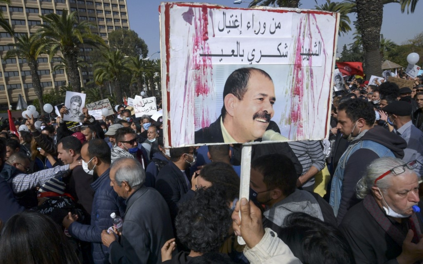 Un manifestant brandit une pancarte demandant à savoir qui a assassiné Chokri Belaïd, lors d’une marche à l’occasion du 8e anniversaire de sa mort, à Tunis le 6 février 2021 (AFP)