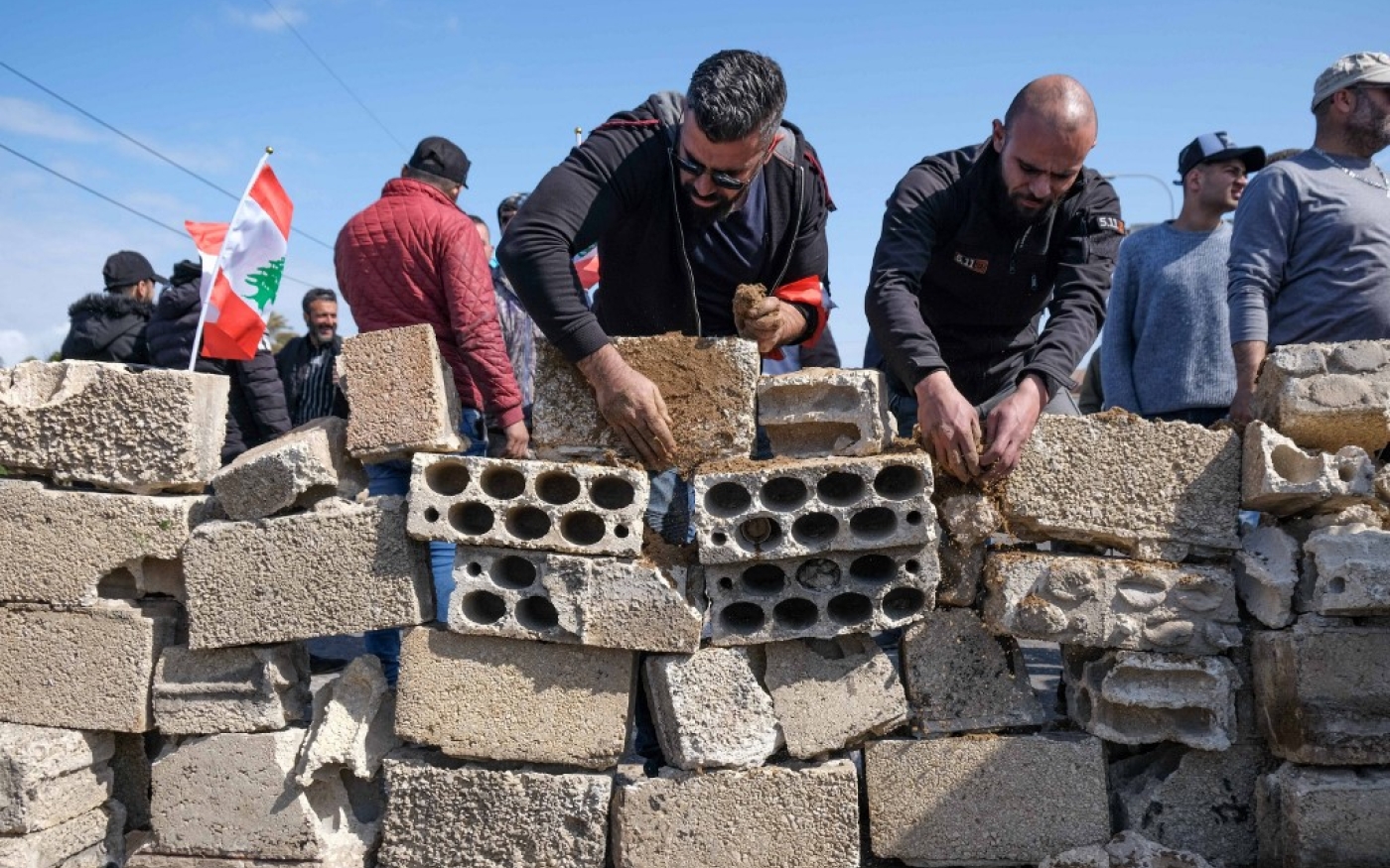 Des manifestants construisent un mur pour fermer l’autoroute à l’entrée sud de Tripoli, le 8 mars 2021 (AFP)