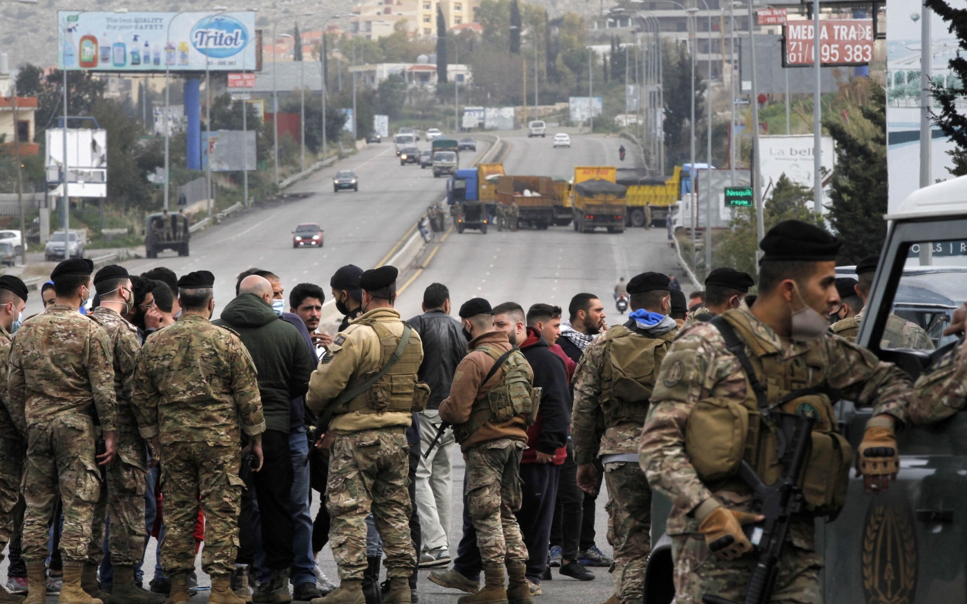 Lebanese security forces try to open a road blocked protesters south of Beirut on 10 March 2021 (Mahmoud Zayyat/AFP)
