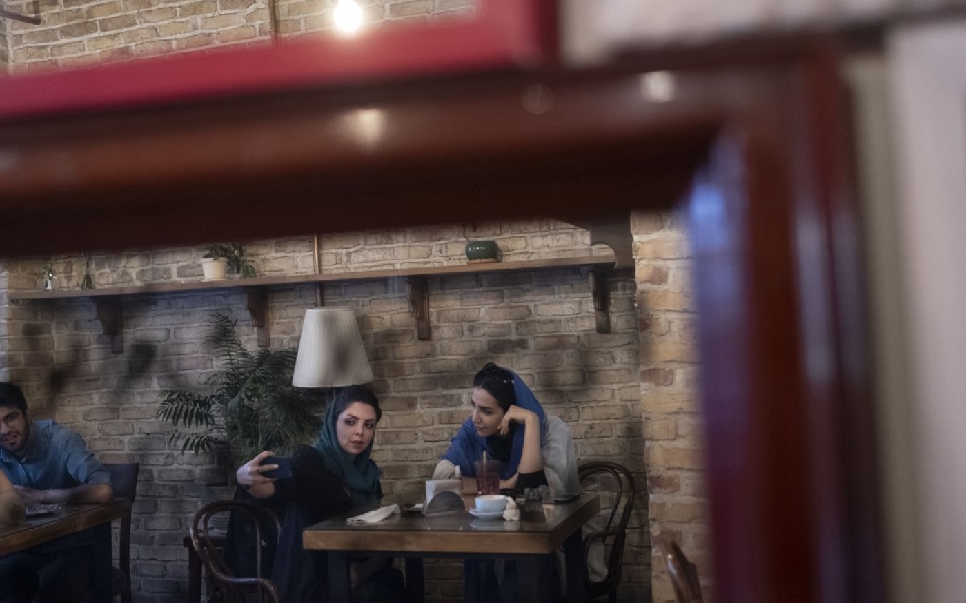 Des Iraniennes prennent un selfie dans un café de Téhéran (AFP/Morteza Nikoubazl)