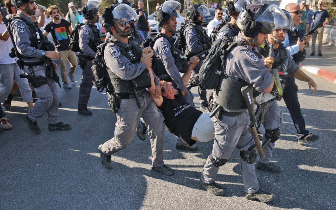 Les forces de sécurité israéliennes arrêtent un activiste près d’un check-point policier à l’entrée du quartier de Sheikh Jarrah, à Jérusalem-Est, lors d’une manifestation le 25 juin 2021 (AFP)