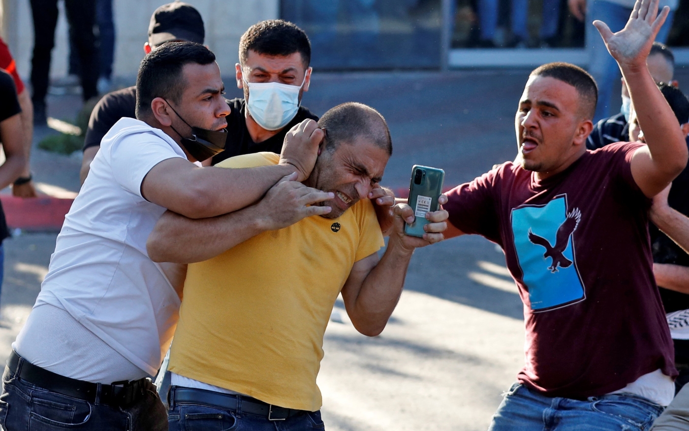 Des membres des forces de sécurité palestiniennes en civil arrêtent un homme au cours d’une manifestation à Ramallah, en Cisjordanie occupée, le 26 juin 2021 (AFP/Ahmad Gharabli)