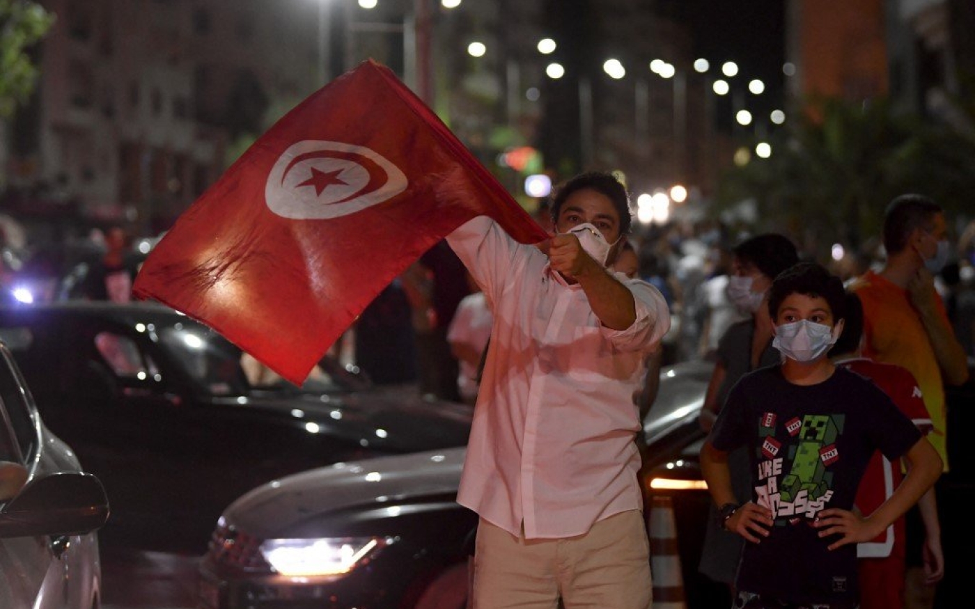 Des citoyens célèbrent la nouvelle de la suspension du Parlement par le président Kais Saied dans les rues de Tunis, le 25 juillet 2021 (AFP) 