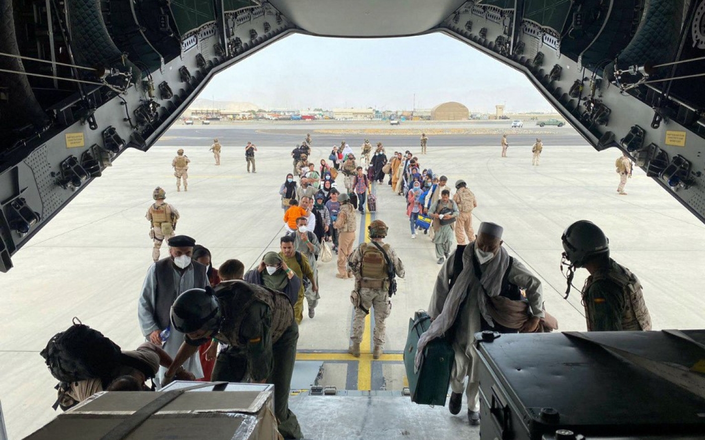 Des Espagnols, des Afghans et leurs familles qui travaillaient pour l’Espagne font la queue pour être évacués, à Kaboul, le 18 août 2021 (AFP)