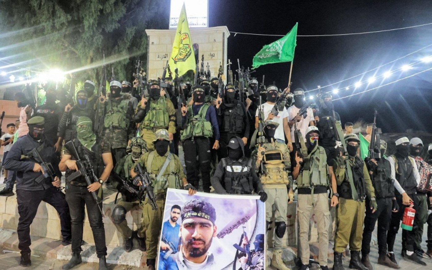 Des hommes armés appartenant aux branches militaires du Fatah, du Hamas et du Jihad islamique posent pour une photo de groupe sur une place du camp de Jénine, le 18 août 2021 (AFP)