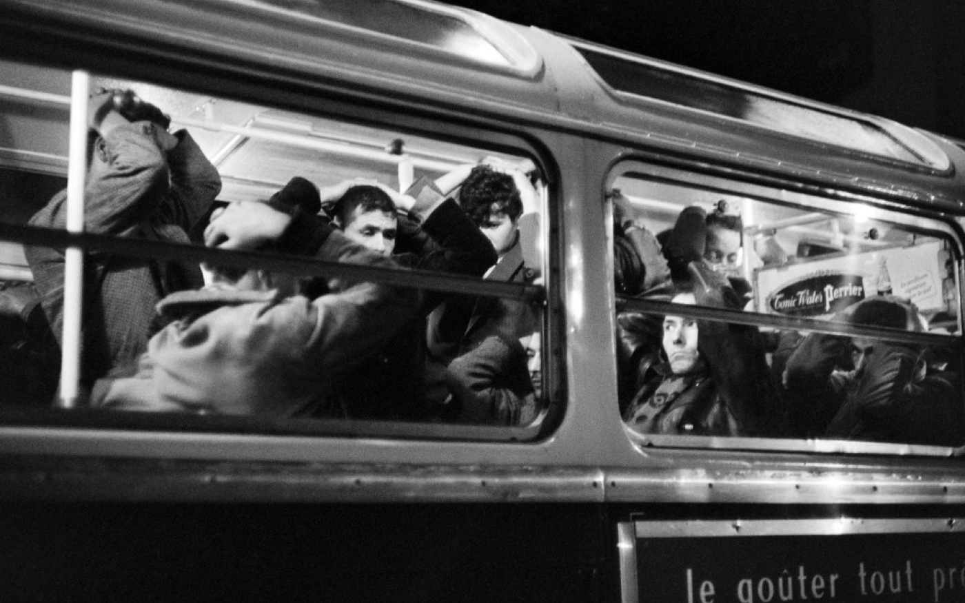 Manifestants algériens arrêtés pendant la manifestation du 17 octobre 1961, dans un bus de la police, les mains sur la tête (AFP)