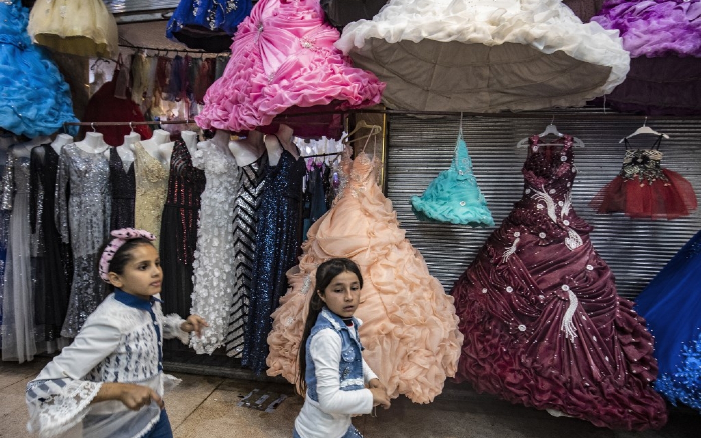 Des fillettes se promènent dans les rues marchandes du centre de Raqqa, le 6 novembre 2021 (AFP/Delil Souleiman)