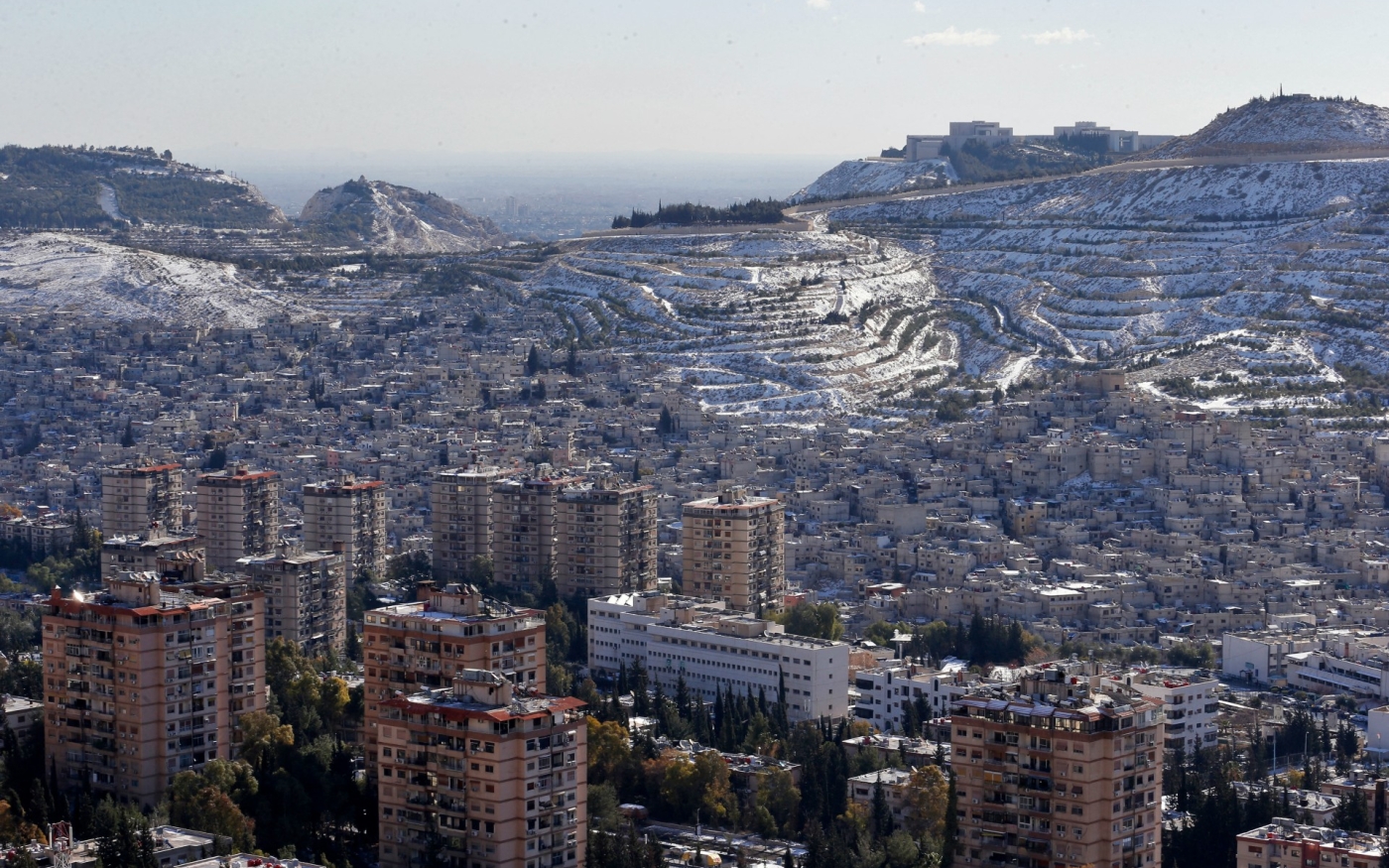 Le mont Qasioun, qui surplombe le quartier de Dummar à Damas, enneigé, le 20 janvier 2022 (AFP)