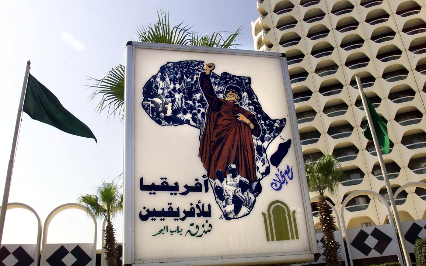 Une affiche de Mouammar Kadhafi sur laquelle on peut lire « L’Afrique appartient aux Africains », apparaît devant l’hôtel Bab al-Bahr (Porte de la mer), à Tripoli, le 17 août 2000 (AFP)