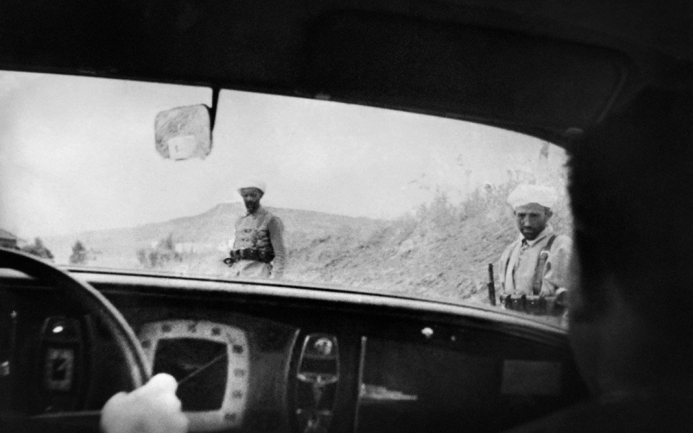 Des soldats marocains aperçus à un poste de contrôle sont photographiés par des journalistes depuis leur voiture alors qu’ils suivent l’avancée des troupes nationalistes, en 1937 (AFP)