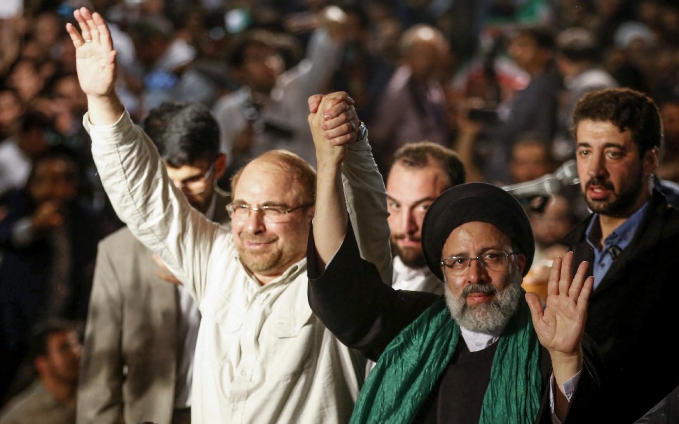 Ebrahim Raïssi (à droite) tient la main de Mohammad Bagher Ghalibaf, ancien candidat à la présidence et maire de Téhéran, lors d’un meeting de campagne à Téhéran, le 16 mai 2017 (AFP)