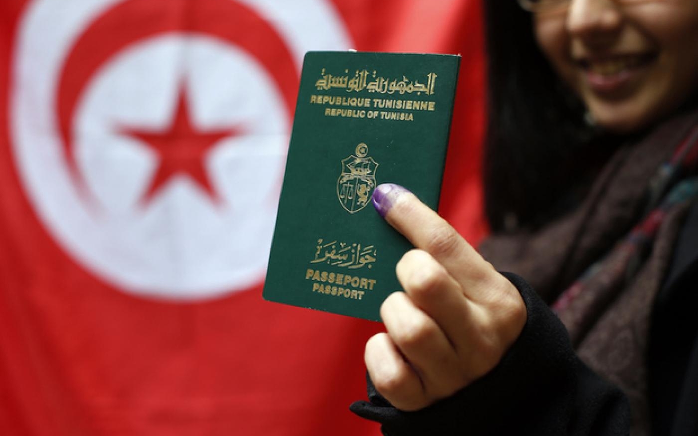 Une Tunisienne montre son passeport au consulat de Tunisie à Paris (AFP)