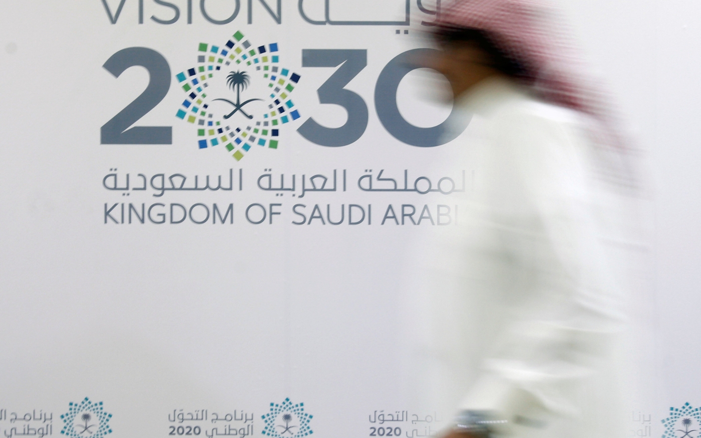 Un homme passe devant le logo de Vision 2030 après une conférence de presse à Djeddah, en Arabie saoudite (Reuters)