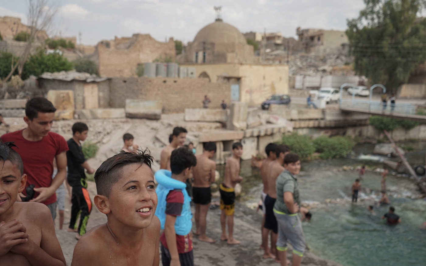 Des enfants irakiens nagent dans la rivière dans la ville dévastée de Tal Afar en septembre 2019 (Reuters)