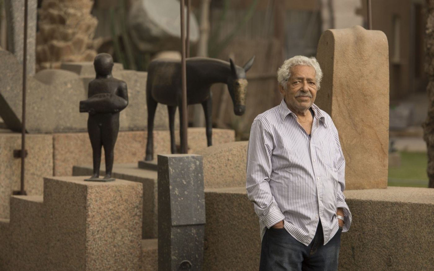 Adam Henein à côté de certaines de ses œuvres exposées au Caire (AFP)