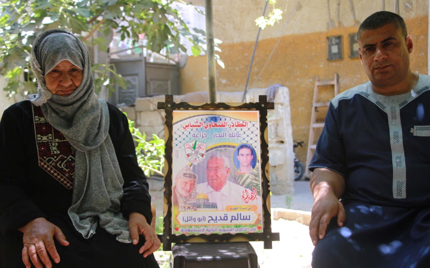 Rasmia et Wissam Kodeih, mère et fils, posent à côté d’une photo de leurs proches tués dans les attaques israéliennes sur Gaza en 2014 (MEE/Ahmed al-Sammak)