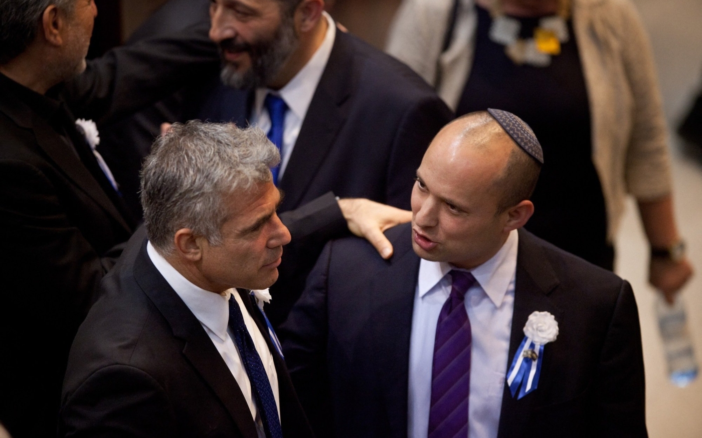Yaïr Lapid (à gauche) donne l’accolade à Naftali Bennett lors d’une réception marquant l’ouverture de la 19e Knesset, le 5 février 2013 à Jérusalem (AFP)