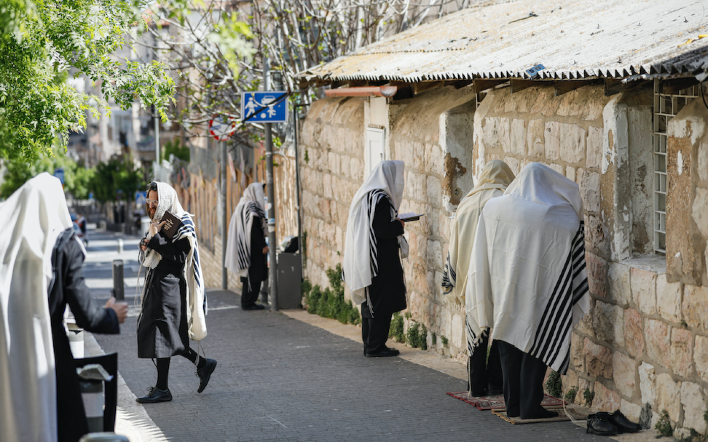 Des juifs ultra-orthodoxes prient dans une rue, à Jérusalem, le 29 mars 2020 (AFP)