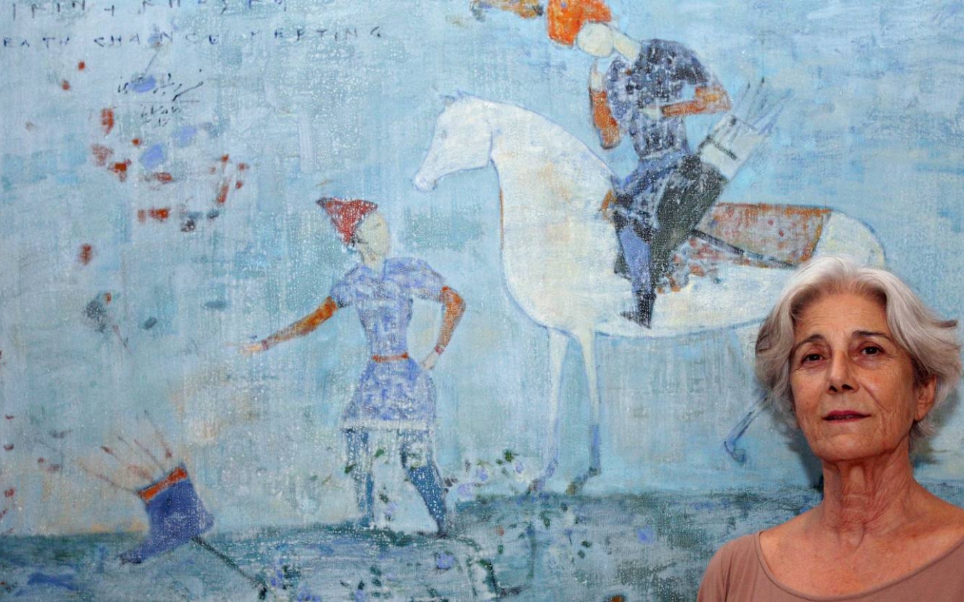 La curatrice Lucia Topalian, directrice de la galerie Dar Al Funoon au Koweït, à côté d’une peinture de l’artiste iranien Reza Derakshani (AFP/Asser Al-Zayyat)