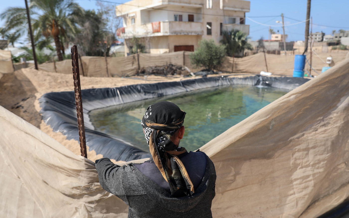 Iyad Shallouf paie environ 100 shekels (environ 30 euros) par jour pour remplir le bassin artificiel de 80 mètres cubes sur ses terres, utilisé pour l’irrigation (Mohammed al-Hajjar/MEE)