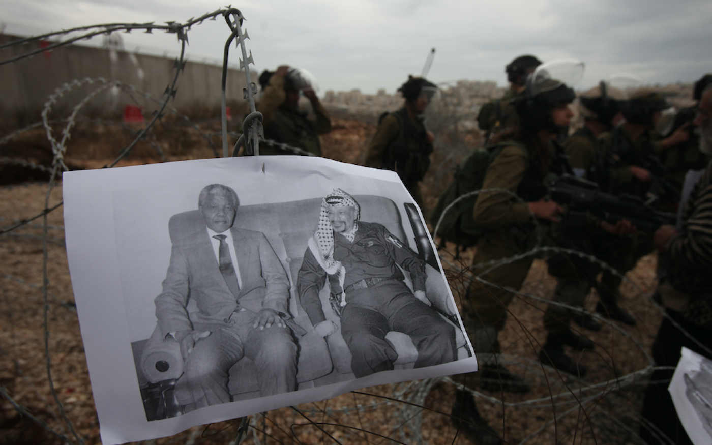 Manifestation d’activistes palestiniens contre l’occupation israélienne, dans le village de Bilin en Cisjordanie occupée, le 6 décembre 2013. Sur la photo, les dirigeants sud-africain Nelson Mandela et palestinien (Yasser Arafat) (AFP)
