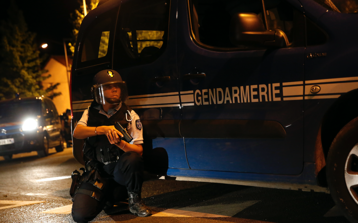 Un gendarme français se met à l'abri derrière un véhicule de police, à Persan près de Beaumont-sur-Oise, le 22 juillet 2016 (AFP)