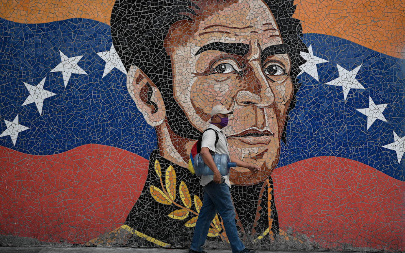 Un homme passe devant une peinture murale représentant le héros de l’indépendance sud-américaine Simon Bolivar, à Caracas, le 17 avril 2020 (AFP)