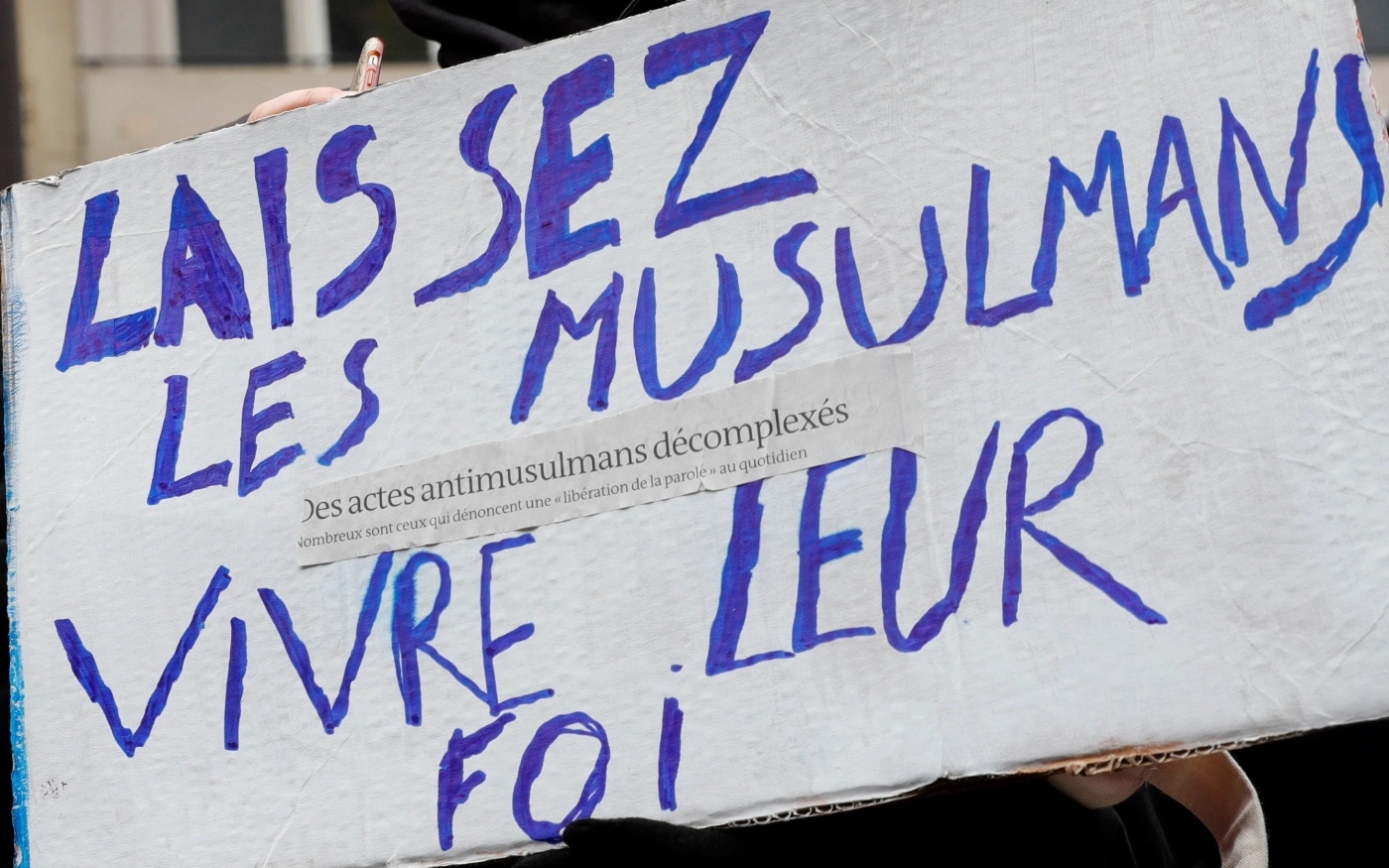 Une pancarte brandie par un manifestant pendant une marche contre l’islamophobie devant la gare du Nord à Paris, le 10 novembre 2019 (AFP)