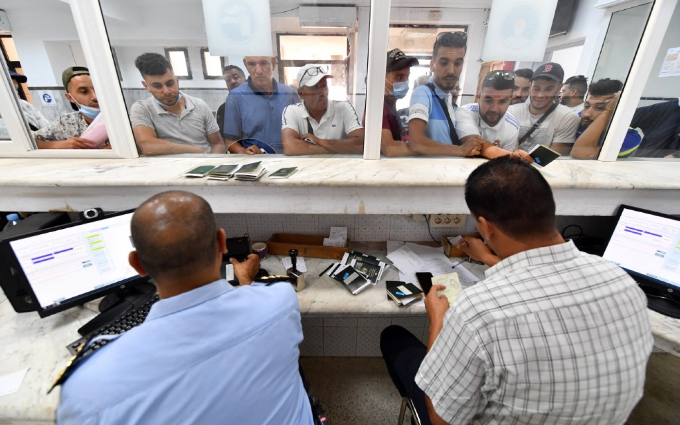 La police des frontières tunisienne contrôle les passeports, le jour de la réouverture de la frontière algéro-tunisienne, le 15 juillet 2022 (AFP/Fethi Belaid)