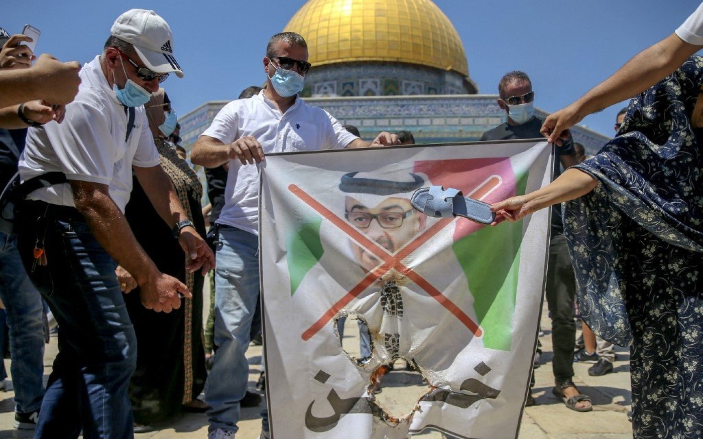 Des manifestants palestiniens se préparent à déchirer un portrait du prince héritier d’Abou Dabi Mohammed ben Zayed au complexe d’al-Aqsa, le 14 août (AFP)