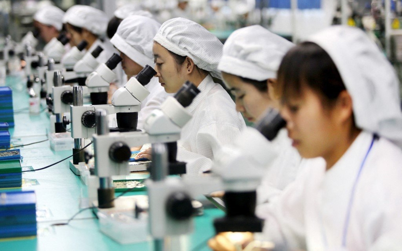 Des employées travaillent sur des composants pour téléphones portables dans une usine dans l’est de la Chine, en mars 2017 (AFP)