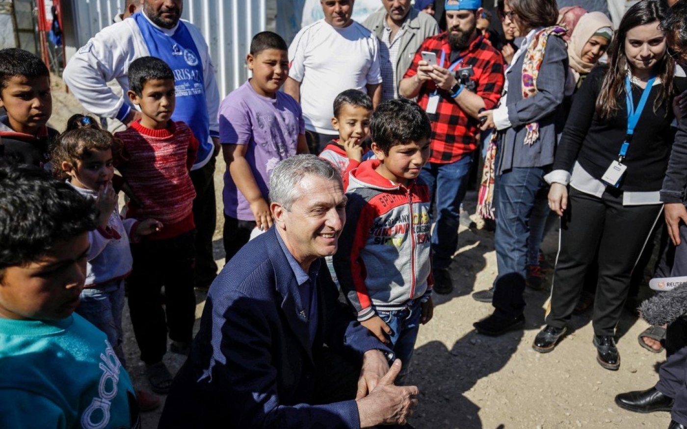 Filippo Grandi, le haut-commissaire aux réfugiés de l’ONU, pose avec des enfants réfugiés syriens dans un camp du nord du Liban, en mars 2019 (AFP)