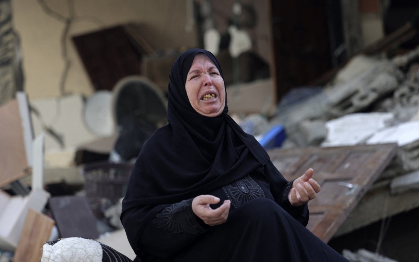 Une femme pleure au milieu des décombres de sa maison frappée par un bombardement, à Gaza, le 7 août 2022 (AFP/ Mohammed Abed)
