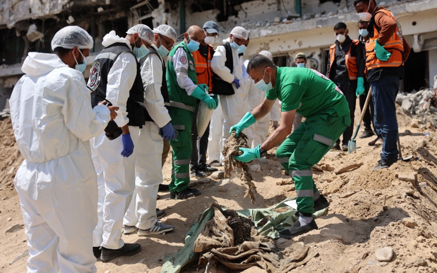 La médecine légale et la Défense civile palestiniennes récupèrent des restes humains dans l’enceinte de l’hôpital al-Chifa, le plus grand hôpital de Gaza, réduit en cendres après un siège israélien de deux semaines, le 8 avril 2024 (AFP)