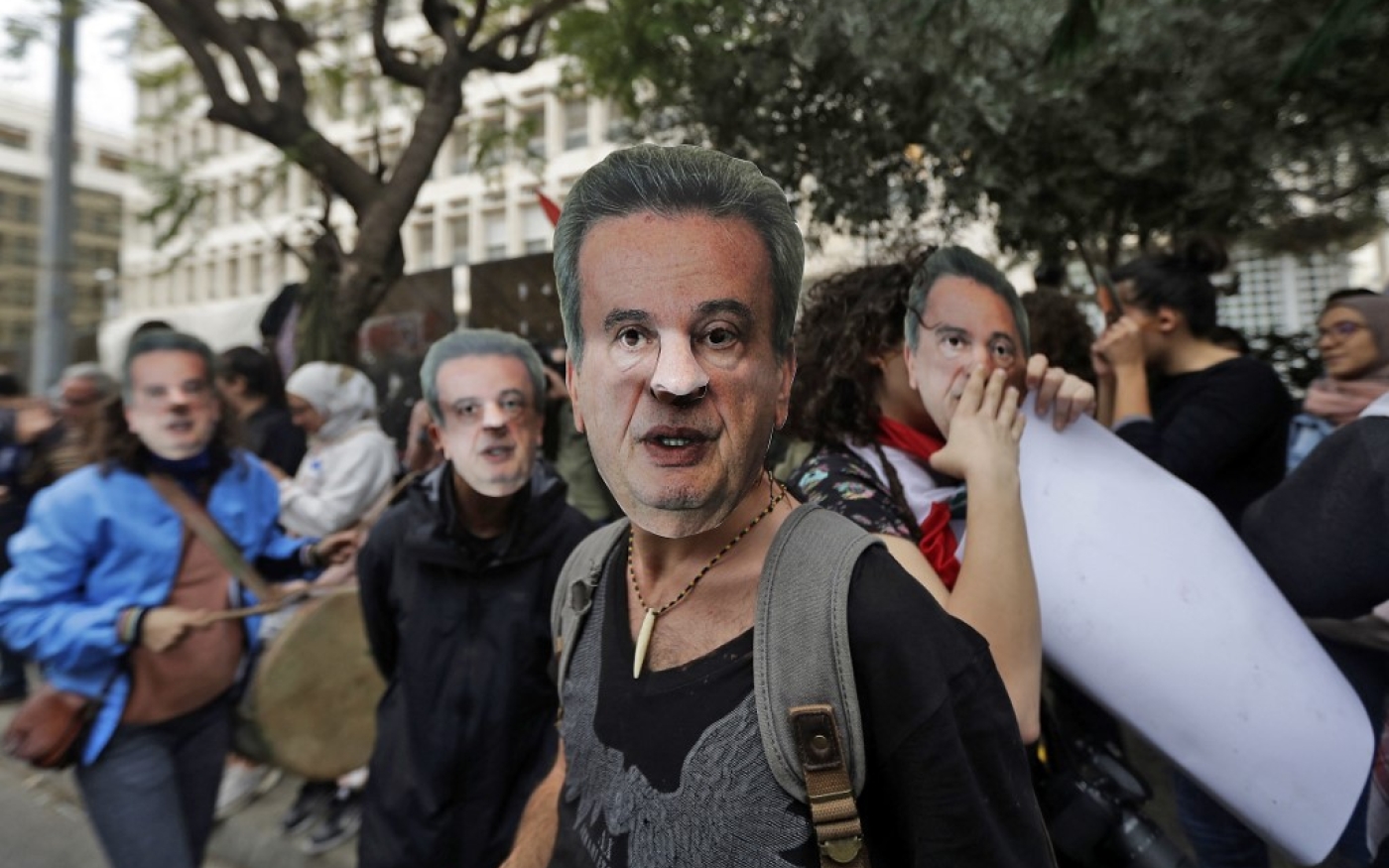 Des manifestants hostiles au gouvernement portent le masque de Riad Salamé devant le siège de la Banque centrale à Beyrouth, en novembre 2019 (AFP)