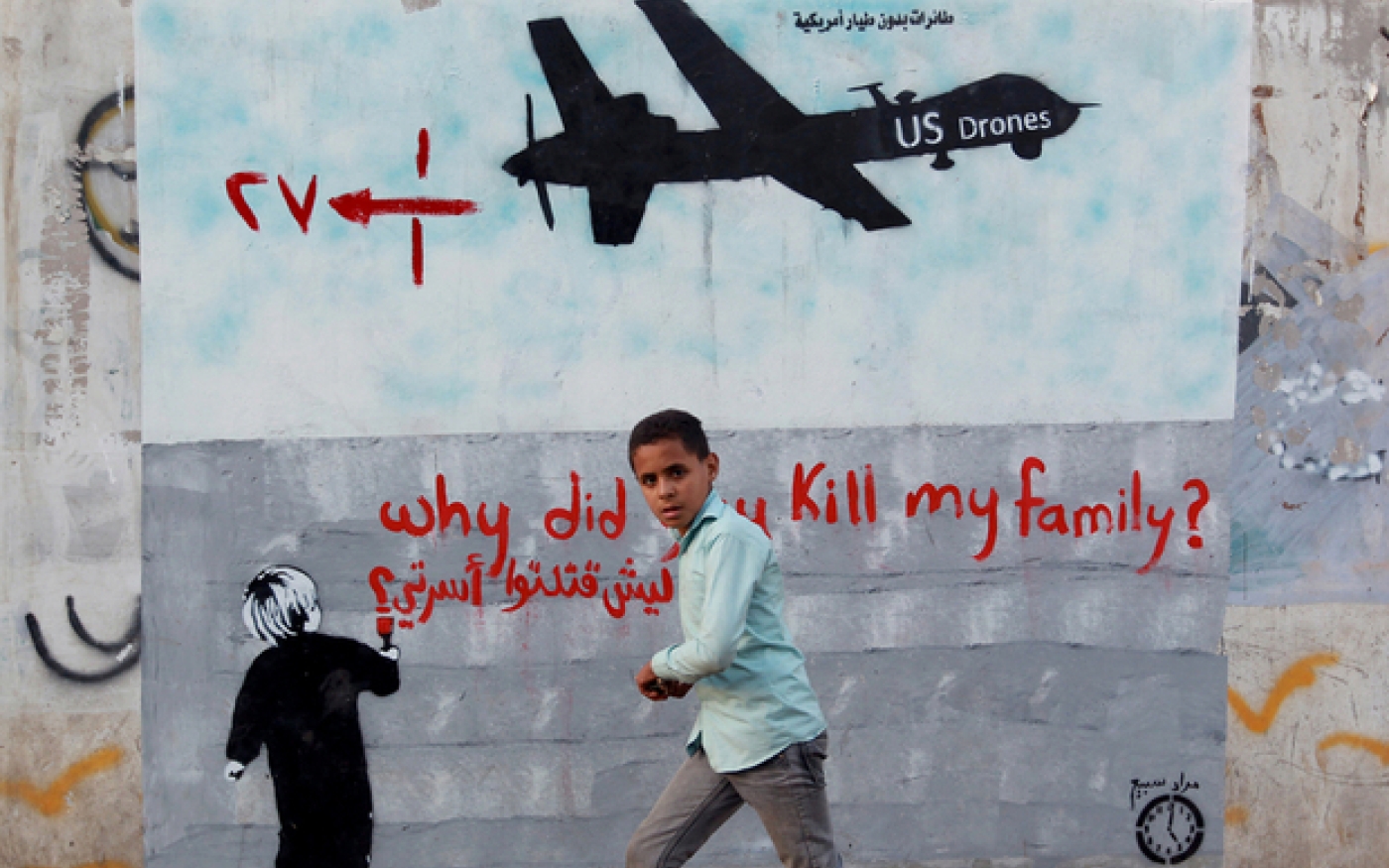 Un garçon de Sanaa passe à côté d’une fresque représentant un drone américain avec le message suivant : « pourquoi avoir tué ma famille ? » (AFP)