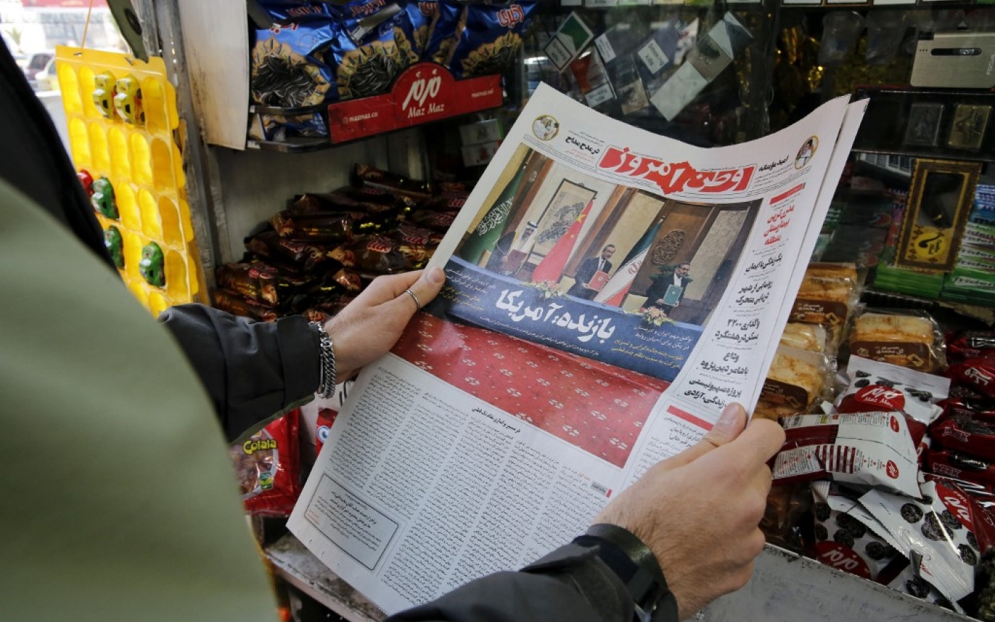 Une Iranienne tient un journal local rapportant en première page l’accord négocié par la Chine entre l’Iran et l’Arabie saoudite pour rétablir les relations diplomatiques, signé à Pékin la veille, le 11 mars 2023 (AFP/Atta Kenare)