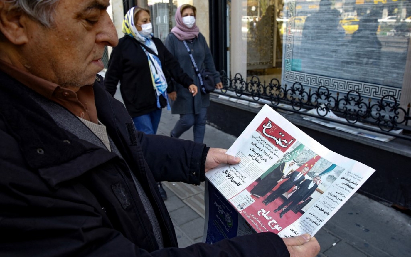 Un homme à Téhéran tient un journal local rapportant sur sa première page l’accord négocié par la Chine entre l’Iran et l’Arabie saoudite pour rétablir les liens, signé à Beijing la veille, le 11 mars 2023 (AFP/Atta Kenare)