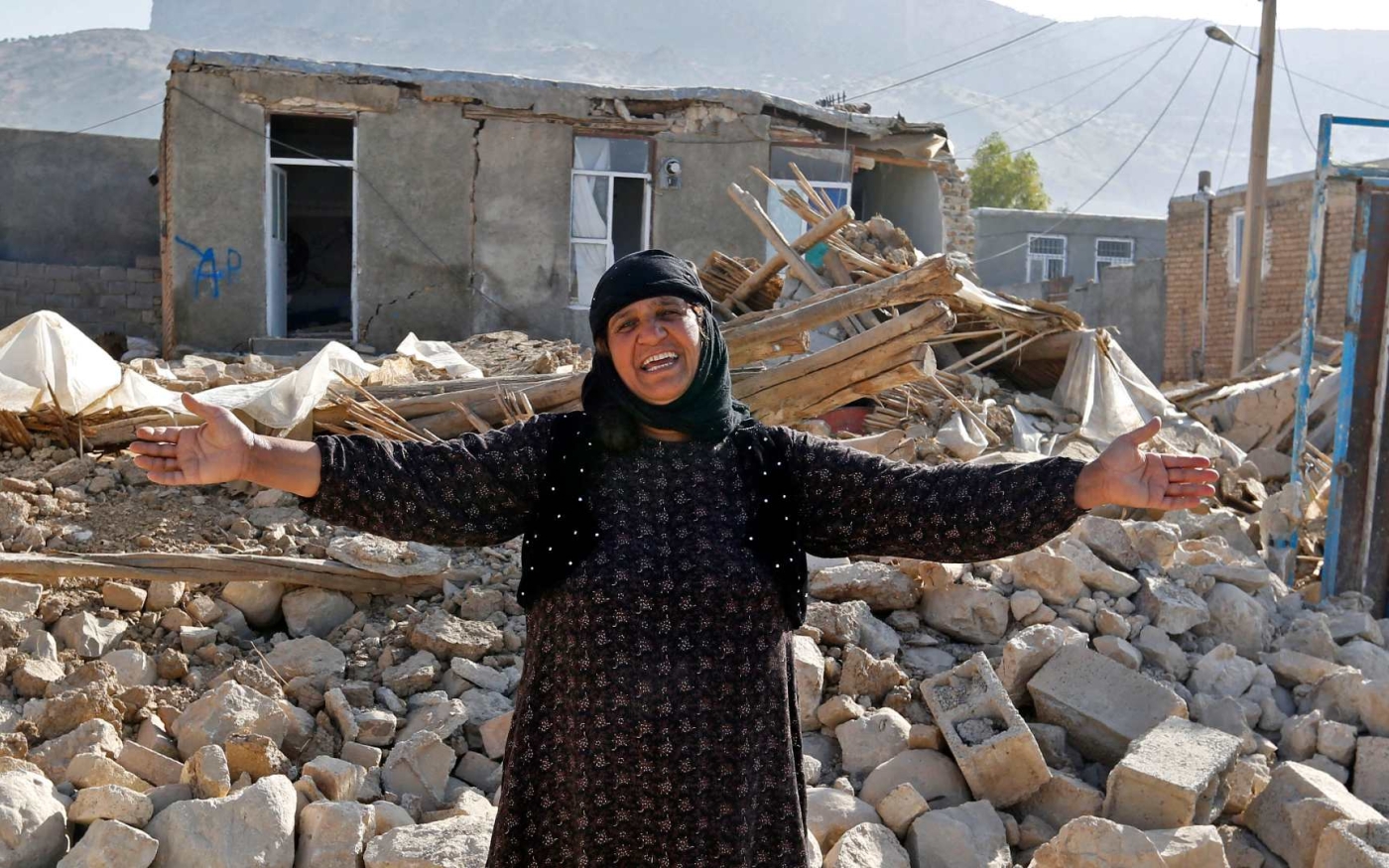 Une femme se tient devant les décombres de sa maison dans la province iranienne de Kermanshah, après le tremblement de terre de novembre 2017 (AFP)