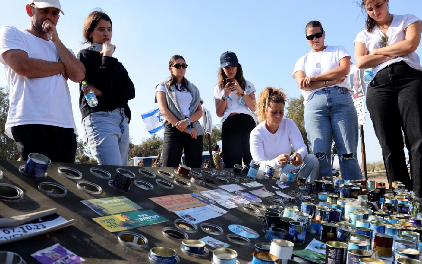 Des Israéliens allument des bougies à la mémoire des jeunes capturés ou tués par des combattants du Hamas le 7 octobre 2023, sur le site du festival de musique Supernova, dans le sud d'Israël, le 7 février 2024 (AFP/Jack Guez)