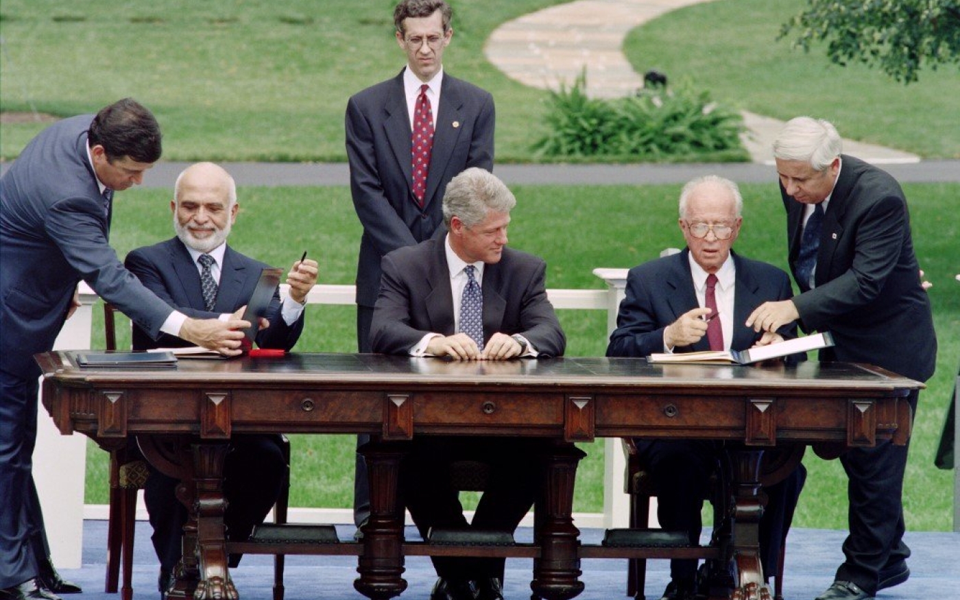 Le Premier ministre israélien Yitzhak Rabin et le roi Hussein de Jordanie signent le traité de paix de 1994 à Washington, sous les yeux du président américain Bill Clinton (AFP)