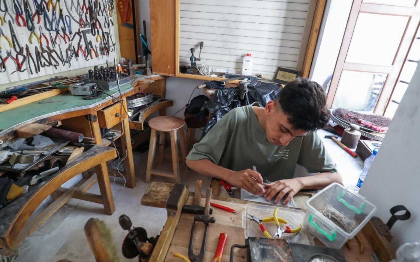 Un jeune Libyen fabrique un morceau de bijou en filigrane traditionnel dans un atelier de la capitale Tripoli, le 8 juin 2022 (AFP/Mahmud Turkia)