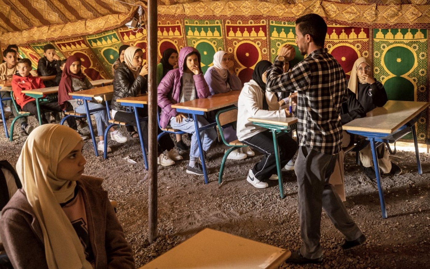 Des élèves suivent des cours sous une tente dans une école de fortune du village d’Asni, frappé par le tremblement de terre, dans la province d’Al-Haouz, dans les montagnes du Haut Atlas, au centre du Maroc, le 18 septembre 2023 (AFP/Fadel Senna)