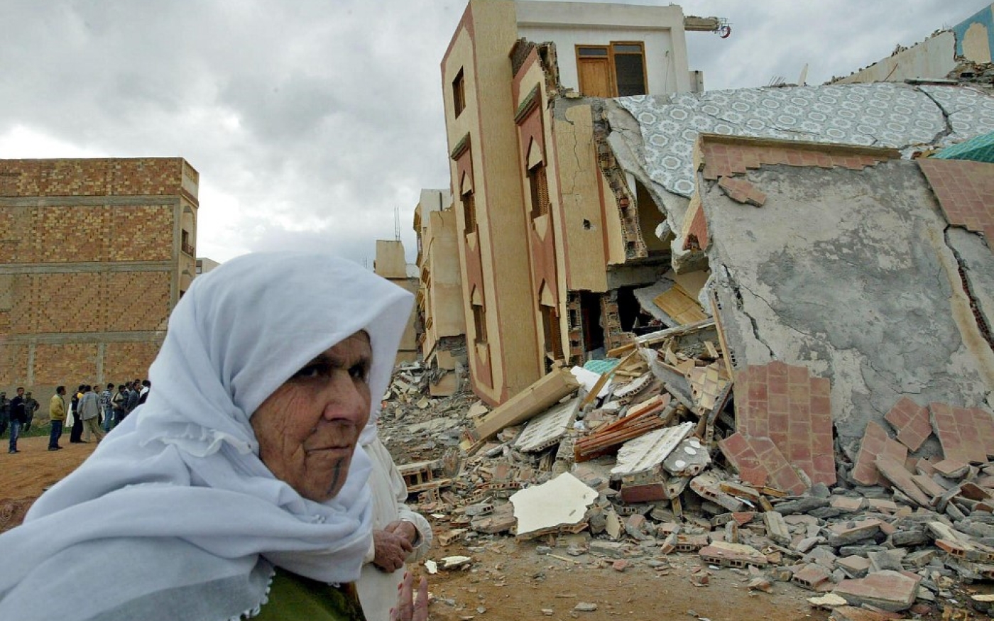 Une Marocaine passe à côté d’un immeuble effondré à Imzouren, au sud d’Al Hoceima, frappé par un séisme de magnitude 6,3, le 24 février 2004 (AFP/Abdelhak Senna)