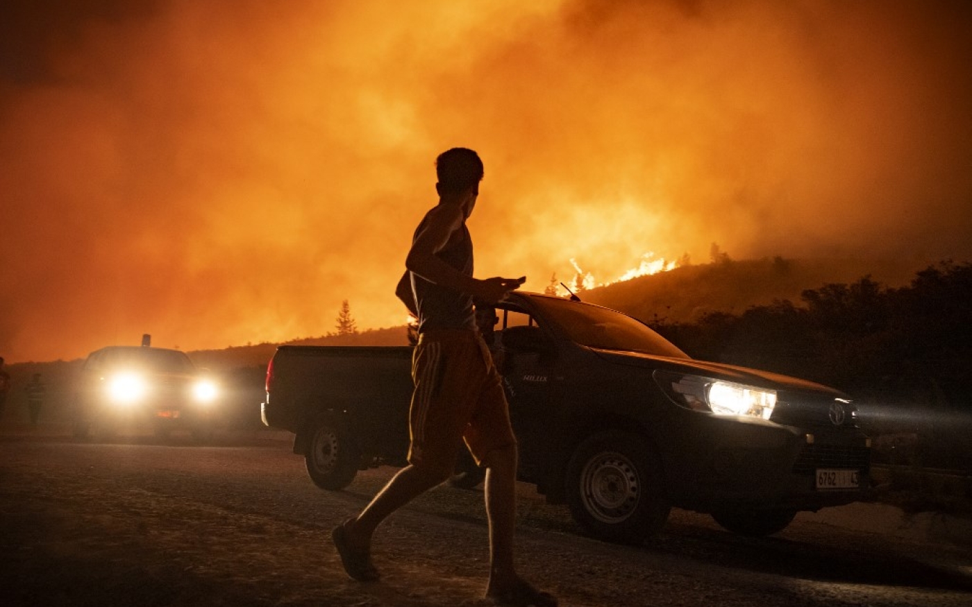 Des Marocains fuient un incendie qui a détruit quelque 200 hectares de forêts dans la région de Chefchaouen, en août 2021 (AFP/Fadel Senna)