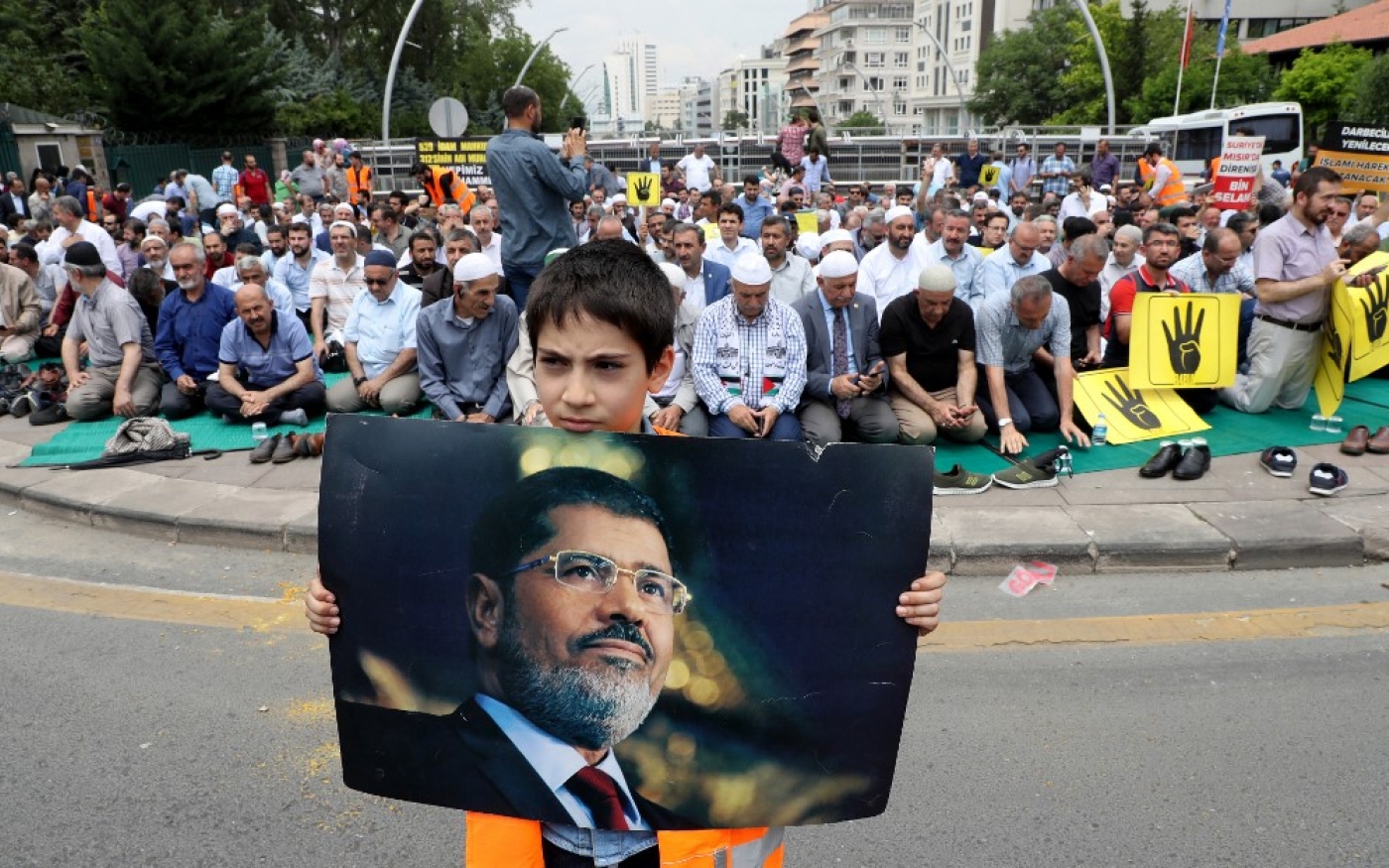 Un garçon tient le portrait de Mohamed Morsi lors d’une prière symbolique en juin 2019 devant l’ambassade d’Égypte à Ankara, en Turquie (AFP/Adem Altan)