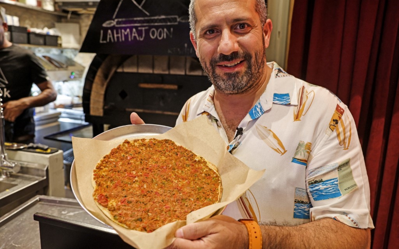 Nassar Odeh, propriétaire du restaurant Taboon, présente une version végétalienne du lahmajoun dans la vieille ville de Jérusalem le 26 juillet 2022 (AFP/Ahmad Gharabli)
