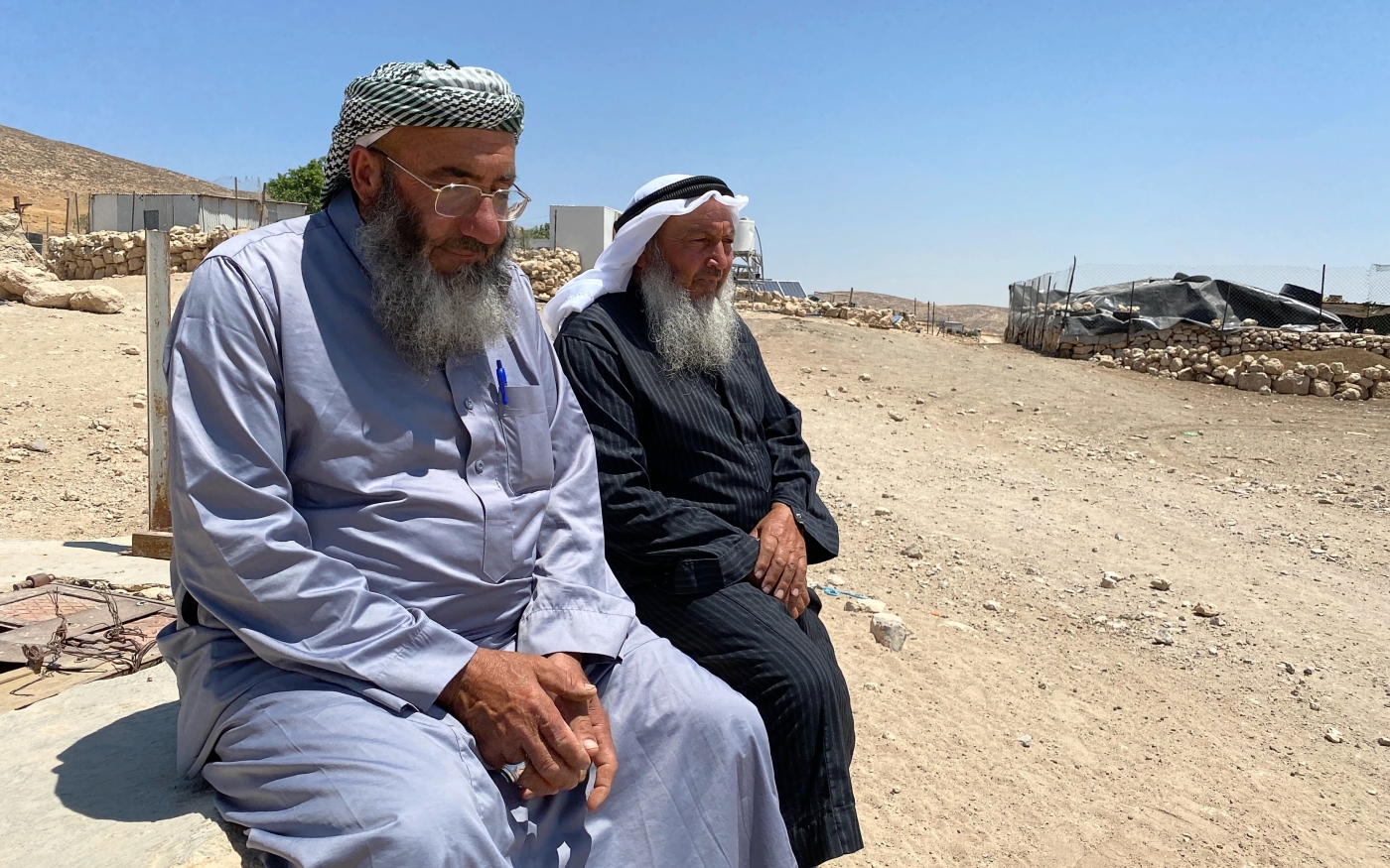 Khaled Khalil Jabarin (à gauche) et Naim Hussein Jaber (à droite) assis près de l’entrée du village de Janba, le 19 juin 2022 (MEE/Shatha Hammad)